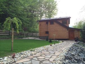 a log cabin with a stone walkway in front of a house at Chata Sklene Teplice in Sklené Teplice