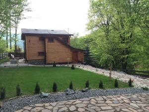 una cabaña de madera en el bosque con un patio verde en Chata Sklene Teplice en Sklené Teplice