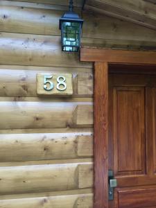 a wooden house with a house number and a door at Chata Sklene Teplice in Sklené Teplice