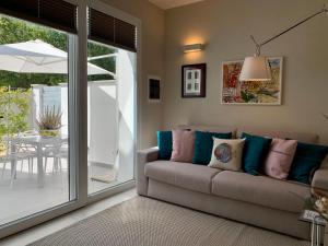 a living room with a couch and a sliding glass door at Villa Luminosa in Torre del Lago Puccini