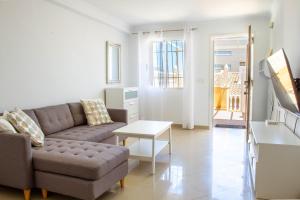 een woonkamer met een bank en een tafel bij Myflats Premium Mirador in Arenales del Sol