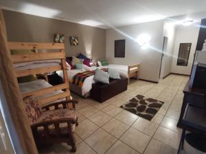 a bedroom with a bed and a couch in a room at Harties Honeymoon suite Mountain side - Hartbeespoort dam in Hartbeespoort
