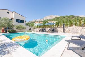 a swimming pool with a boat in the middle at Apartments Garden in Baška