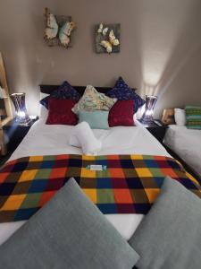 a large bed with a colorful blanket on it at Harties Honeymoon suite Mountain side - Hartbeespoort dam in Hartbeespoort