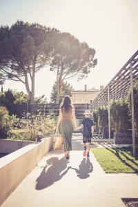 a woman and a child walking down a sidewalk at 514 Appart Hotel in Carcassonne