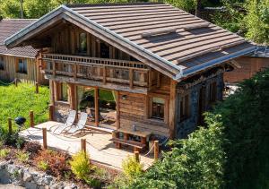 une grande maison en bois avec un banc sur une terrasse dans l'établissement Chalet Hohneck 4 étoiles, vieux bois et pierre, SPA, sauna, borne de recharge, à Stosswihr