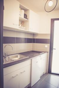 uma cozinha com armários brancos e um lavatório em 514 Appart Hotel em Carcassonne