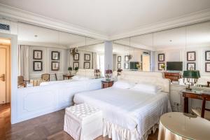 a bedroom with a white bed and a bath room at Excelsior Palace Portofino Coast in Rapallo