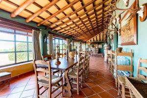 a dining room with a wooden table and chairs at Casa Alta Finca El Revuelo in Las Navas de la Concepción