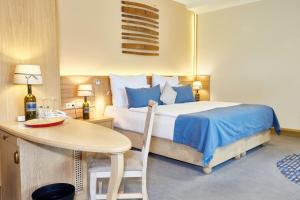 1 dormitorio con cama, mesa y escritorio en Crocus Gere Bor Hotel Resort & Wine Spa en Villány