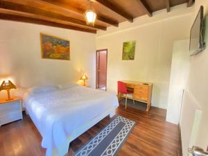 una camera da letto con un letto, una scrivania e una televisione di Hostal Alcala a Quito