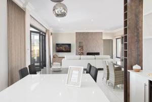 Champagne Valley的住宿－Eleven on Tumbleweed, Cathkin Estates，用餐室以及带白色桌椅的起居室。