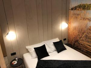 una camera con un letto bianco con due cuscini di Nautica Resort Ekskluzywny apartament z widokiem na jezioro Niegocin a Giżycko