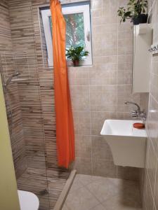 an orange shower curtain in a bathroom with a sink at ТИХОТО МЯСТО in Burgas City