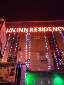 a sign on the side of a building with lights at Sun Inn Residency in Mumbai