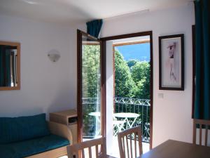 a living room with a couch and a balcony at Les jardins Ramel in Luchon