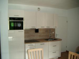 a kitchen with white cabinets and a sink at Les jardins Ramel in Luchon