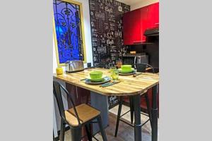 a kitchen with a wooden table with green dishes on it at Appartement cosy avec baignoire balnéo in Boulogne-sur-Mer