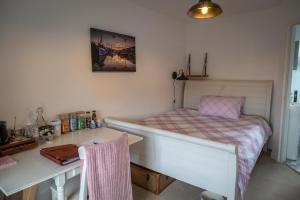 a small bedroom with a bed and a desk at Stone's throw Cottage Mevagissey in Mevagissey
