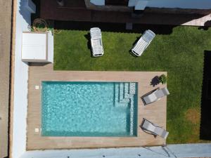 uma vista superior de uma piscina com duas cadeiras de jardim em Chalet Santi Playa de la Barrosa em Chiclana de la Frontera