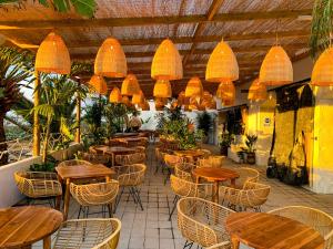 a restaurant with wooden tables and chairs and lights at Jacío House in Moya