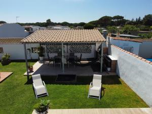 um quintal com cadeiras e um gazebo em Chalet Santi Playa de la Barrosa em Chiclana de la Frontera