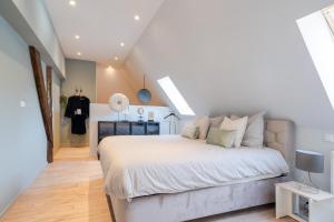 a bedroom with a large white bed in a attic at 99 Lifestyle Suite in Zwaag