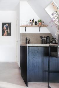 a kitchen with a dark wooden counter in a room at 99 Lifestyle Suite in Zwaag