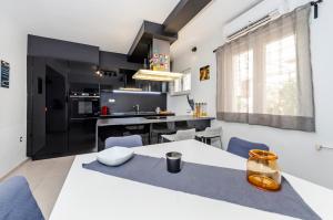 a kitchen with a white table and blue chairs at Apartment Cave in Rovinj