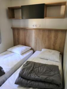two beds in a small room withermottermott at Mobil Home Camping Mayotte Biscarrosse in Biscarrosse