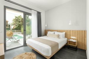 a bedroom with a bed and a sliding glass door at Yuka Villas Collection in Iraklitsa