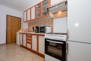 a kitchen with a stove and a refrigerator at Apartment in Mundanije with Seaview, Terrace, Air condition, WIFI (3748-1) in Mundanije