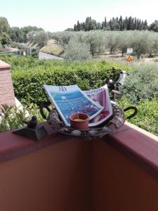 a table with a laptop on a balcony with a candle at Country House Martina in Castelnuovo Berardenga