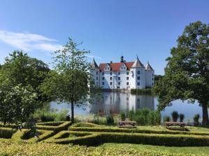 ein großes Gebäude auf einem See in der Unterkunft Seaside in Glücksburg
