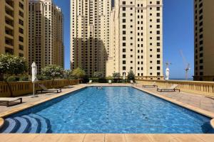 a large swimming pool in a city with tall buildings at The Smart Concierge - Bahar 6 in Dubai