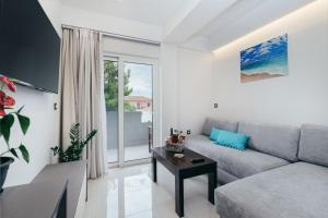 uma sala de estar com um sofá e uma mesa em Corner45 Apartments em Kalamaki