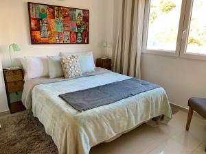 een slaapkamer met een bed met een schilderij aan de muur bij Beachfront apartment in Fuengirola in Fuengirola