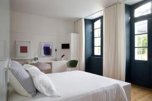 a bedroom with a white bed and a bathroom at CHASSE-SPLEEN Les Chambres in Moulis-en-Médoc
