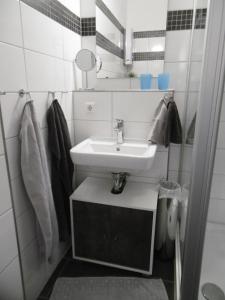 ein weißes Badezimmer mit einem Waschbecken und einem Spiegel in der Unterkunft Ferienwohnung am Südstrand 2 in Burgtiefe auf Fehmarn 