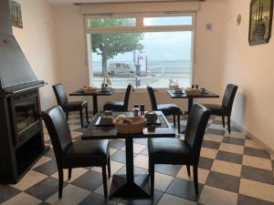 a dining room with tables and chairs and a window at Les Mouettes Blessées in Le Crotoy