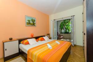 um quarto com uma cama com paredes cor de laranja e uma janela em Seaside Apartments Antičević em Bobovišća