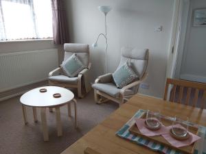 a living room with two chairs and a table at The Gem in Winchelsea