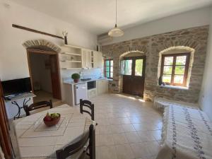 eine Küche und ein Esszimmer mit einem Tisch und Stühlen in der Unterkunft Pension Sofia Amorgos in Katápola