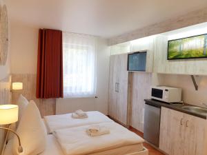 レスラートにあるZimmer for youのベッド2台と電子レンジが備わるホテルルームです。