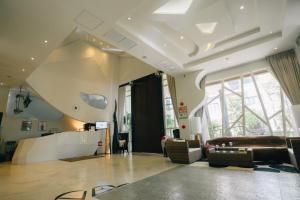 a living room with a couch and a large window at Zotel in Chiang Mai