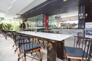 a restaurant with a long table and chairs at Zotel in Chiang Mai