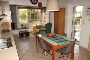 kuchnia i salon ze stołem i krzesłami w obiekcie Kato Posidonia Sounio. The house with lemon trees w mieście Lawrio