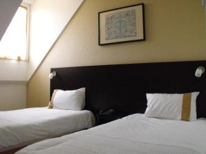 Postel nebo postele na pokoji v ubytování Hôtel d'Alsace
