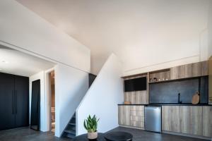 a kitchen with white walls and a staircase at Colombos Beachfront in Foinikiá