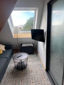 ein kleines Wohnzimmer mit einem Sofa und einem TV in der Unterkunft Studio Vue Mer in Boulogne-sur-Mer